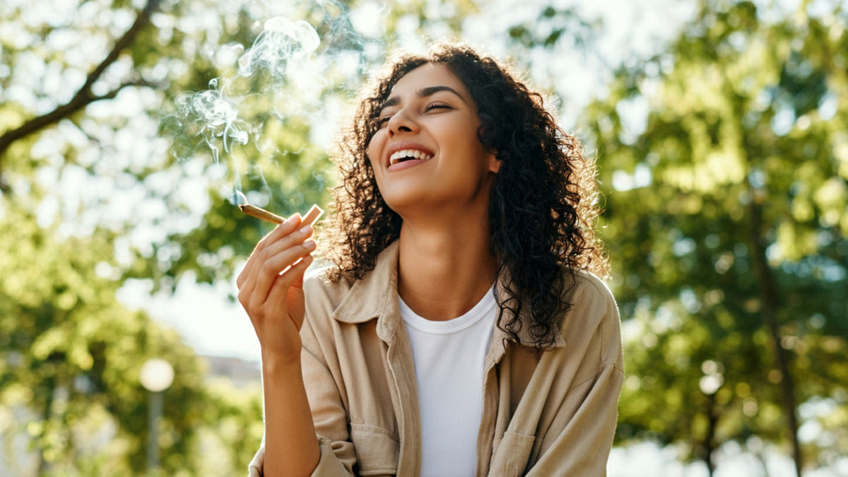 Woman smiling outside and smoking a nine realms cannabis joint