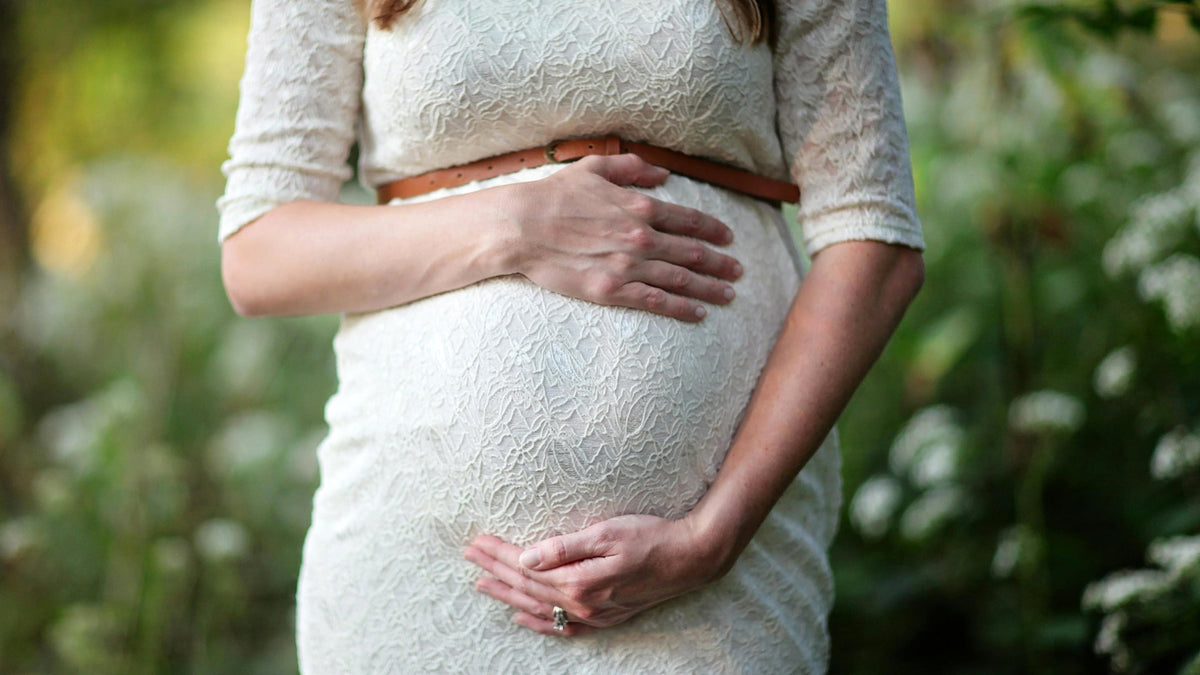 Woman Holding a Future Nine Realms Customer In Her Stomach