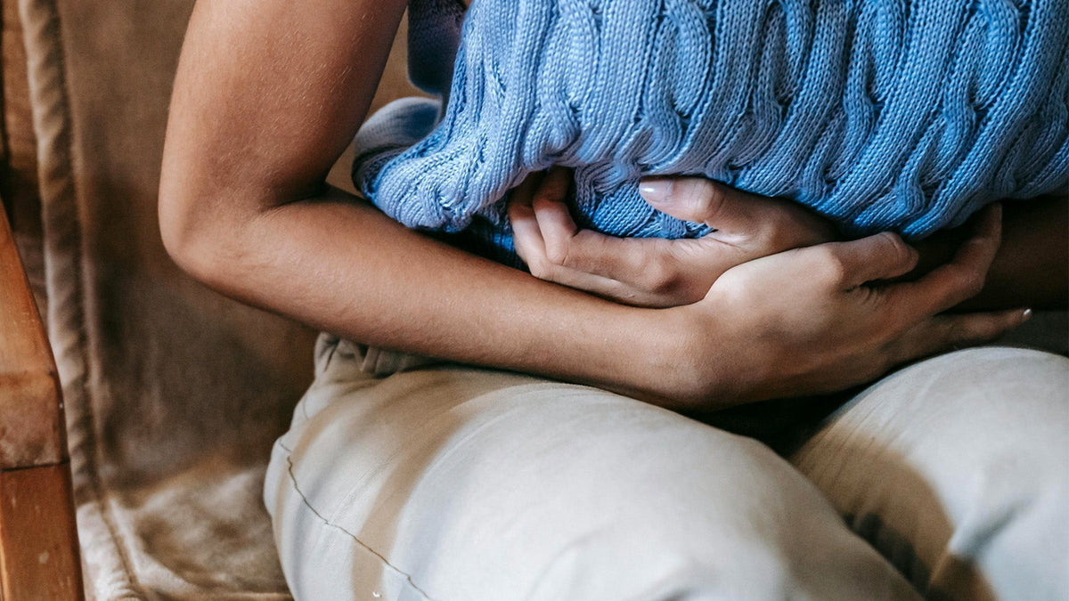 Nine Realms Customer Woman Holding Her Stomach