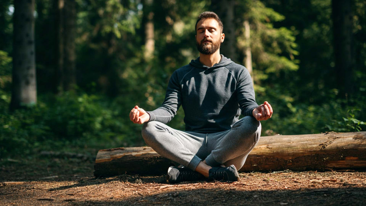 Nine Realms customer meditating in the forest with his legs crossed
