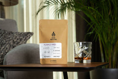 nine realms purple haze classic T9HC cannabis flower on the table with a glass of whiskey next to it