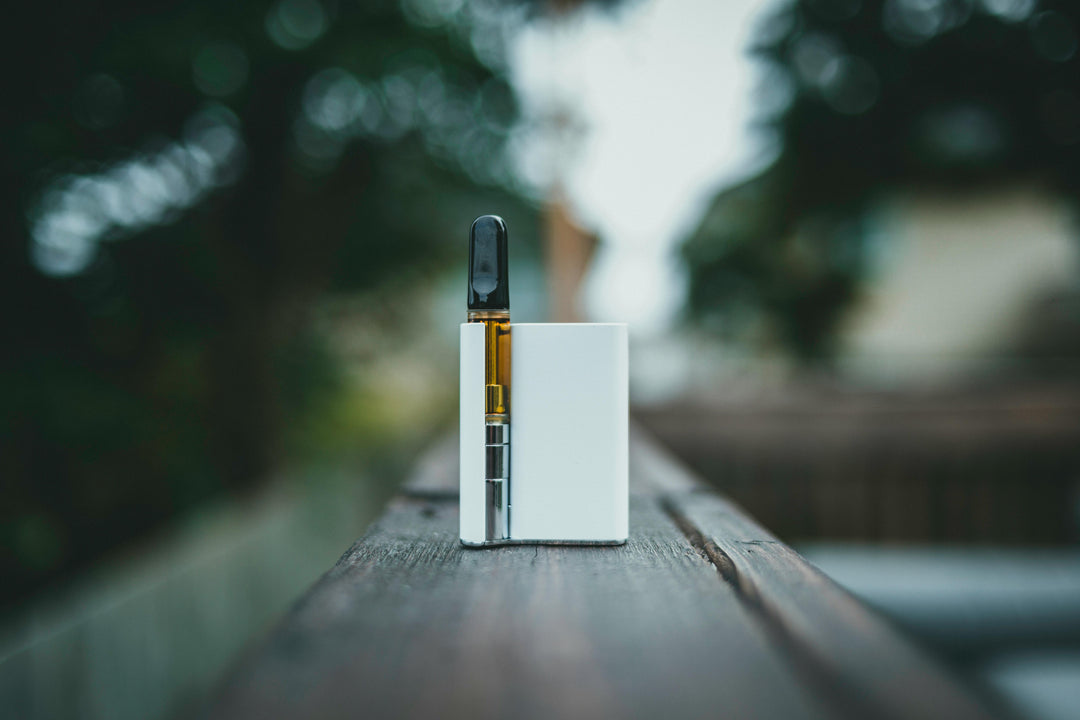 Nine Realms CBD Cartridge Vape Laying on the wood plank outside