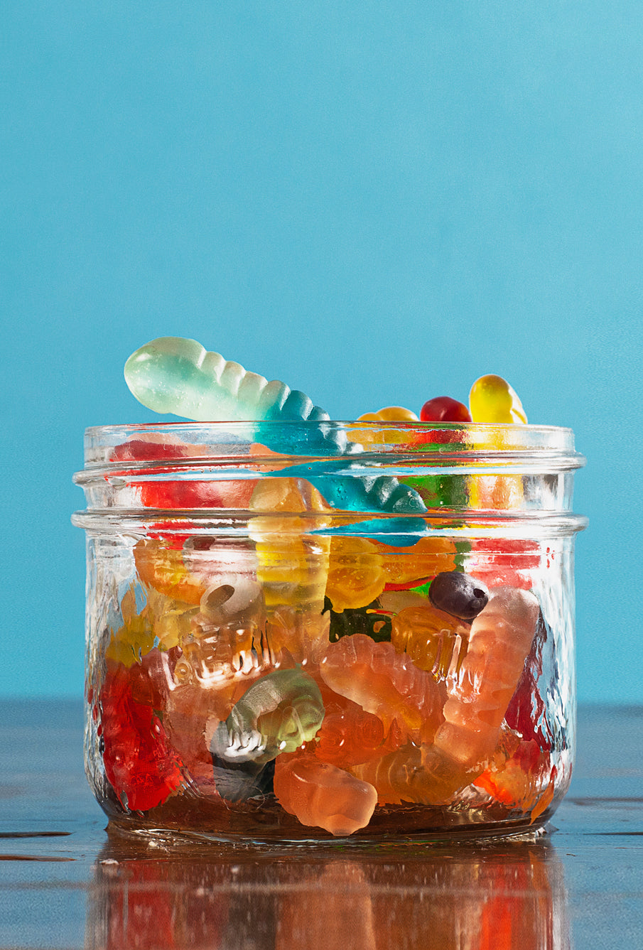 Nine Realms THCP Gummies on the table top in a glass jar